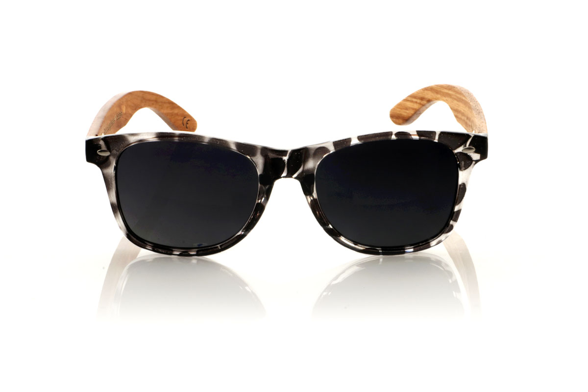 Wood eyewear of Walnut KHUN. KHUN are the new must-have for sunglasses lovers. With its design inspired by the classics, these glasses feature a transparent Tortoiseshell frame in a palette of gray and black with a satin gloss finish, bringing a modern mix to an iconic style. The Walnut temples not only contrast beautifully with the frame, but also add a touch of warmth and naturalness. Perfect for any occasion, the KHUN offers clear vision and protection without compromising style. With measurements of 152x49 and a caliber of 54, they fit perfectly, promising comfort and an impeccable look to those who wear them. for Wholesale & Retail | Root Sunglasses® 